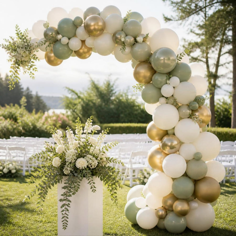 Arche de ballons de mariage asymétrique ivoire, sauge et or champagne sur une pelouse de cérémonie