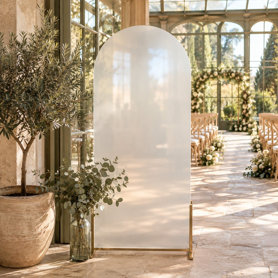 Grand panneau de plan de table en acrylique dépoli en forme d'arche sur pied doré, dans une orangerie lumineuse